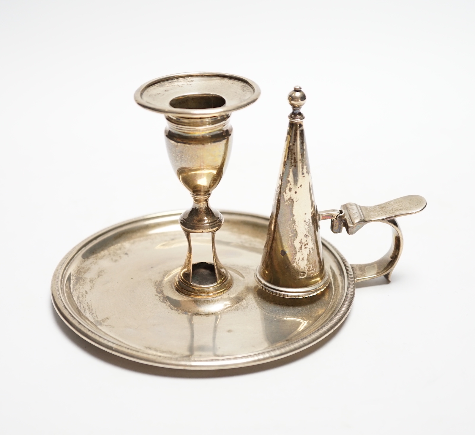 A George III silver chamberstick, John Mewburn, London, 1801, with extinguisher(marks rubbed), diameter 13.7cm, 9.7oz.